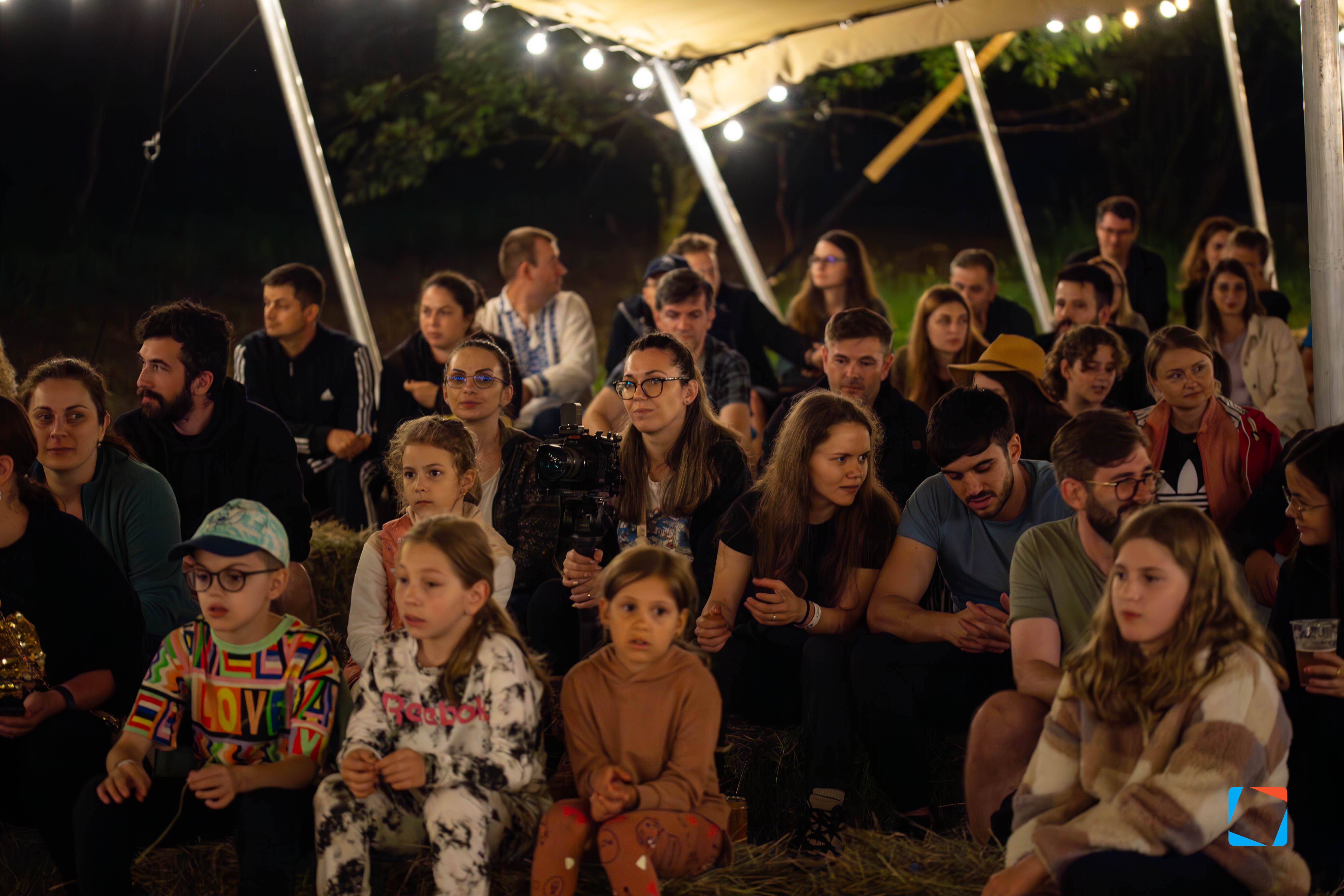 Qubiz team and their families under a string-lit tent at the yearly gathering